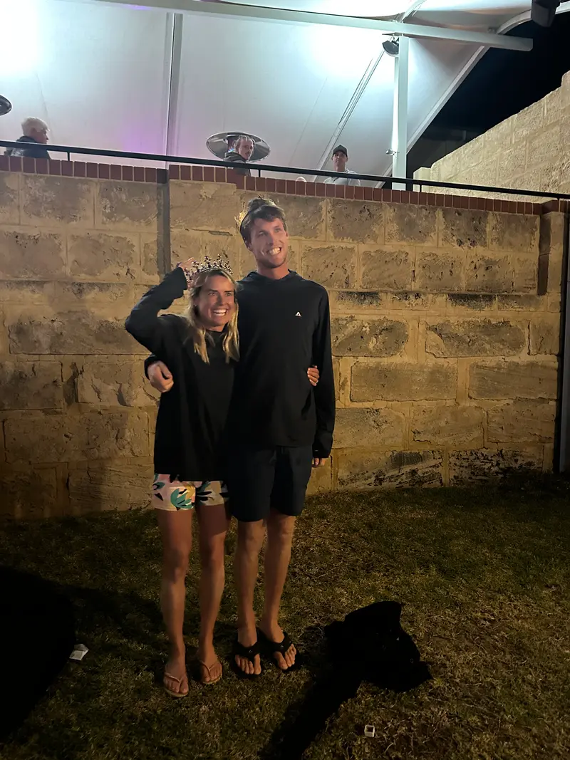 Two award winners wearing crowns celebrate together at the awards night